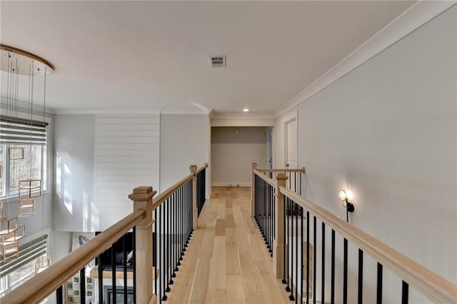 corridor featuring crown molding and light hardwood / wood-style flooring