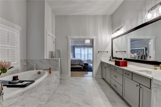 bathroom with vanity and a relaxing tiled tub