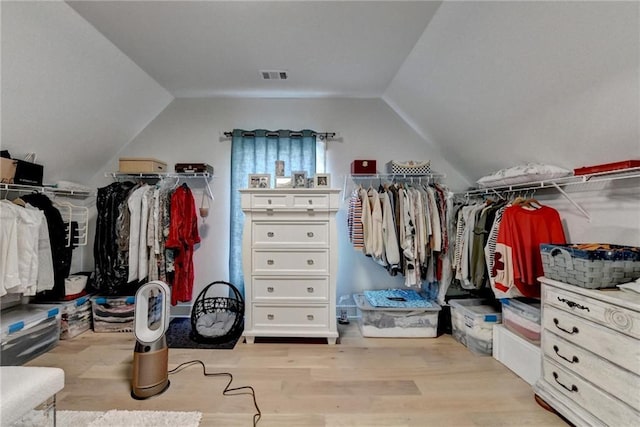 walk in closet with lofted ceiling and light hardwood / wood-style flooring