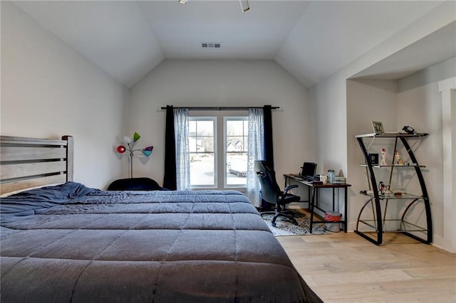 bedroom with vaulted ceiling and light hardwood / wood-style floors