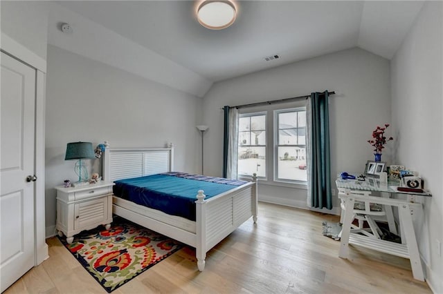 bedroom featuring light hardwood / wood-style flooring and vaulted ceiling