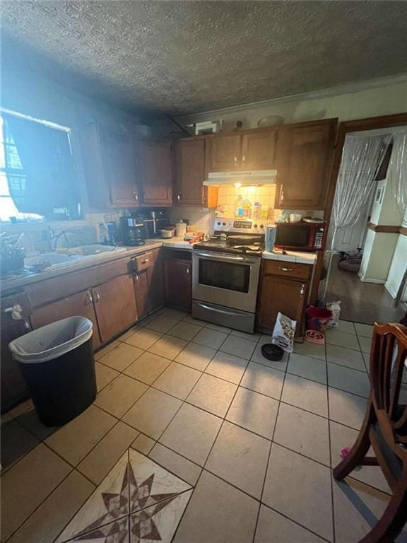 kitchen featuring stainless steel electric range oven, crown molding, fume extractor, a textured ceiling, and light tile floors