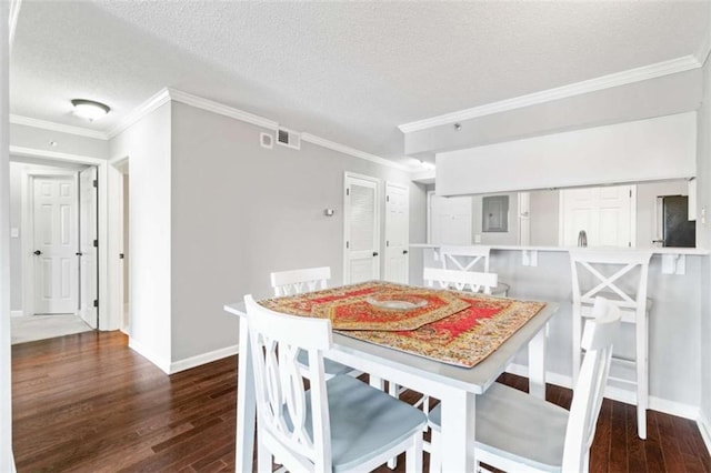 dining area featuring ornamental molding, dark wood-type flooring, a textured ceiling, and baseboards