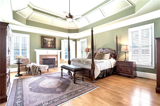 13037 Overlook Pass, Roswell, GA 30075 - bedroom featuring multiple windows, a fireplace, light wood-type flooring, and a raised ceiling