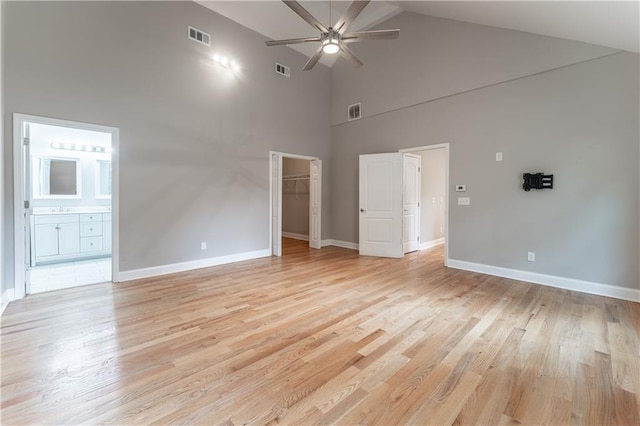 interior space with connected bathroom, sink, a walk in closet, and light hardwood / wood-style flooring