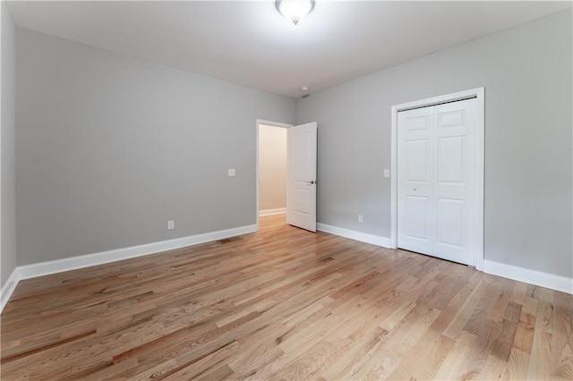 unfurnished bedroom featuring a closet and light hardwood / wood-style flooring