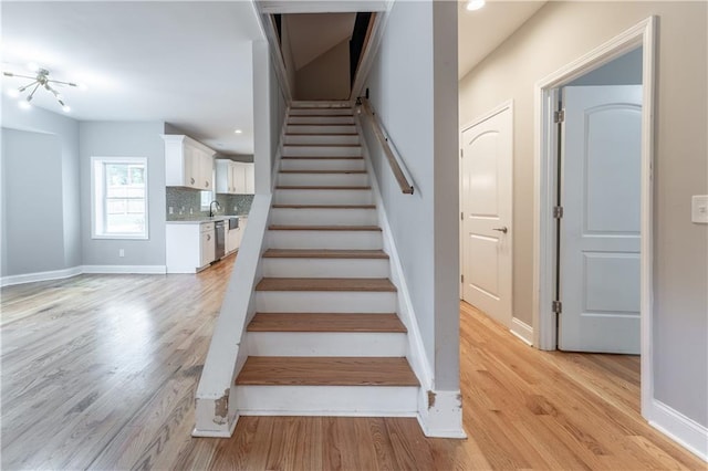 stairs with sink and hardwood / wood-style floors