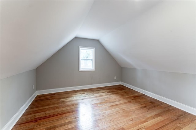 additional living space with lofted ceiling and light hardwood / wood-style flooring