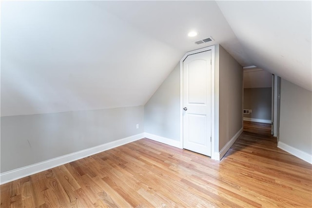 additional living space with lofted ceiling and light hardwood / wood-style floors