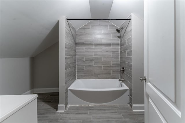 bathroom with tiled shower / bath and vaulted ceiling