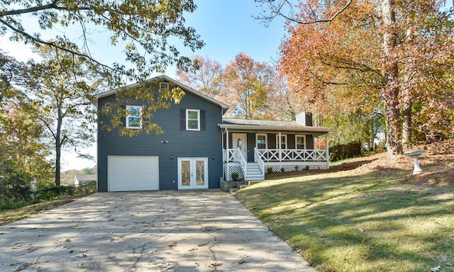 tri-level home with covered porch, french doors, a garage, and a front yard