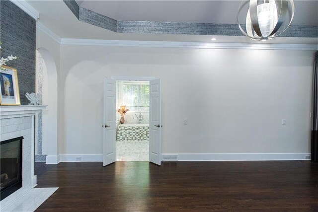 3258 Bransley Way, Duluth, GA 30097 - unfurnished living room with wood finished floors, a tiled fireplace, ornamental molding, and arched walkways