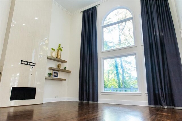3258 Bransley Way, Duluth, GA 30097 - unfurnished living room with crown molding, healthy amount of natural light, a high ceiling, and wood finished floors