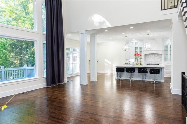 3258 Bransley Way, Duluth, GA 30097 - living area featuring ornate columns, dark wood-style floors, and a towering ceiling