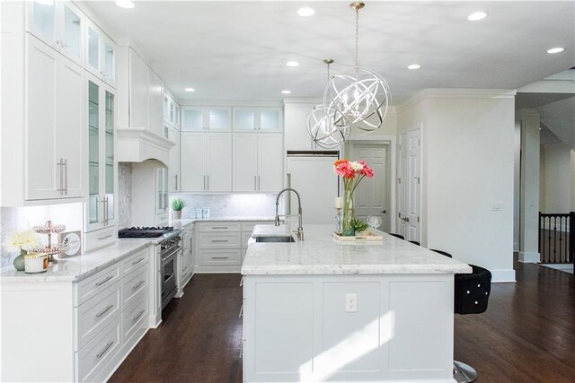 3258 Bransley Way, Duluth, GA 30097 - kitchen featuring high end stove, dark wood finished floors, a center island with sink, recessed lighting, and white cabinetry