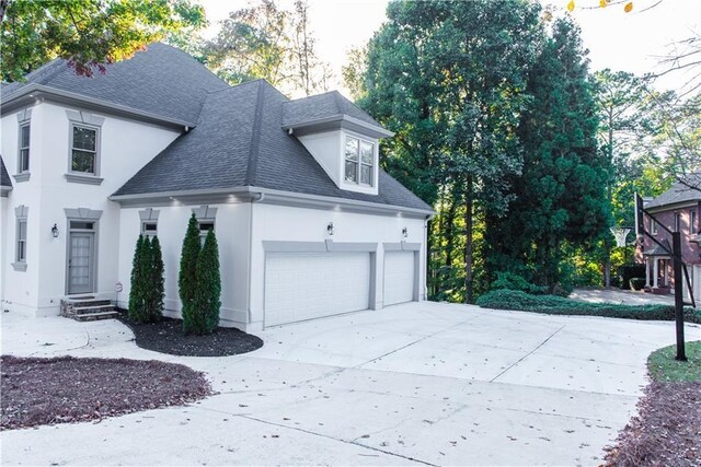 3258 Bransley Way, Duluth, GA 30097 - view of property exterior featuring a shingled roof, stucco siding, driveway, and an attached garage