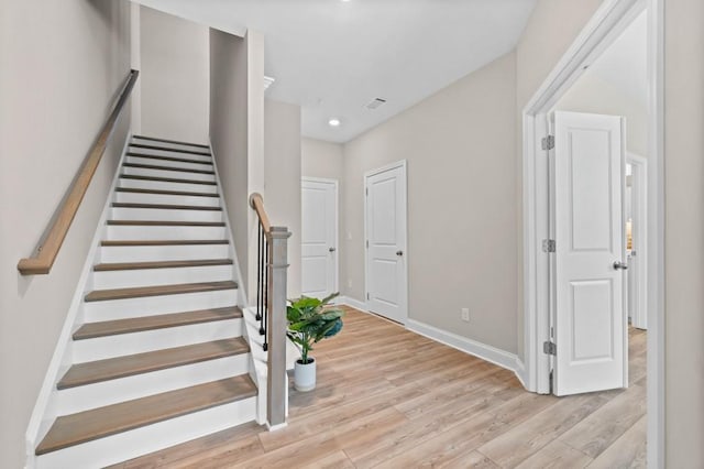 stairway featuring wood finished floors, baseboards, and recessed lighting