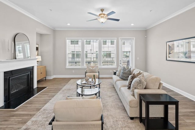 living room featuring wood finished floors, ceiling fan, recessed lighting, crown molding, and baseboards