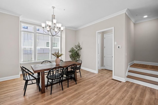 dining room with a chandelier, healthy amount of natural light, crown molding, light wood-style floors, and baseboards