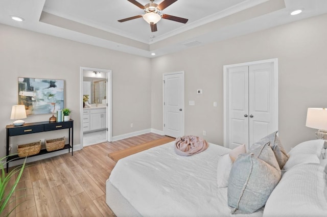 bedroom featuring a raised ceiling, light wood-style flooring, recessed lighting, baseboards, and ceiling fan