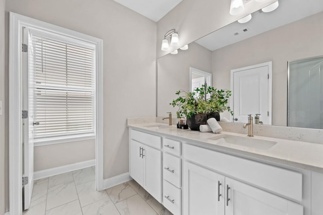 full bath with marble look tiles, baseboards, and double vanity