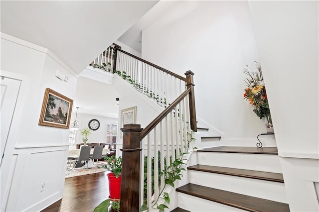 stairs featuring hardwood / wood-style flooring and ornamental molding