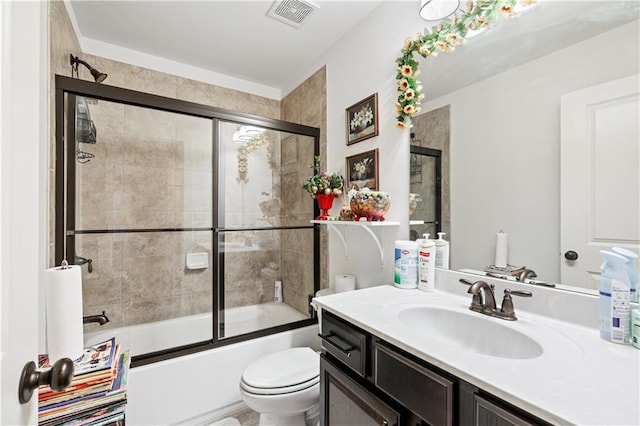 full bathroom featuring combined bath / shower with glass door, toilet, and vanity