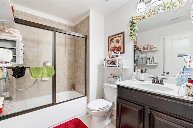 full bathroom featuring combined bath / shower with glass door, tile patterned floors, vanity, and toilet