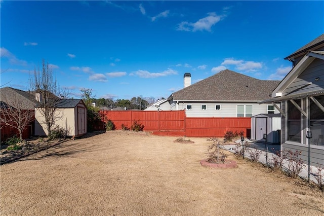 view of yard featuring a sunroom and a storage shed