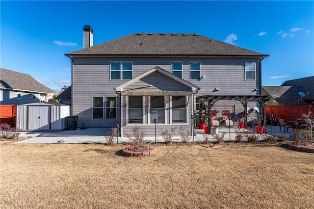 rear view of house featuring a pergola, a storage shed, a sunroom, a patio, and a lawn