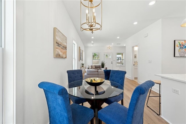 dining space with recessed lighting, baseboards, a notable chandelier, and light wood finished floors