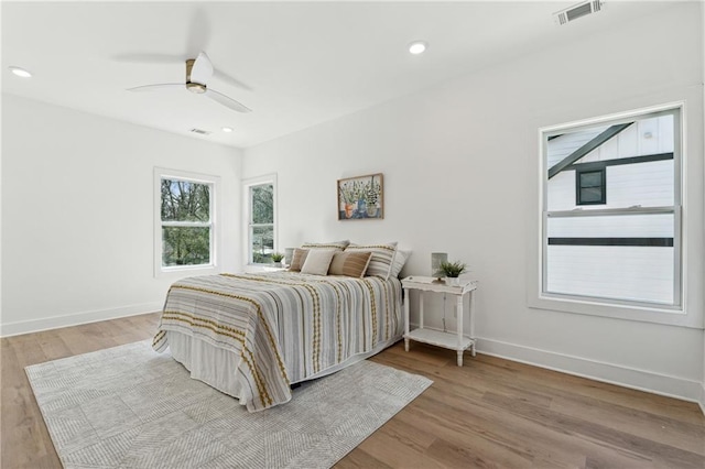 bedroom with light wood finished floors, baseboards, and visible vents