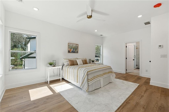 bedroom featuring baseboards, wood finished floors, and recessed lighting