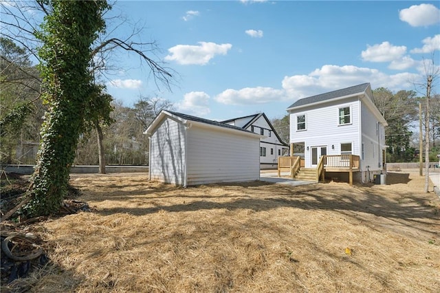 rear view of house featuring an outdoor structure and a deck