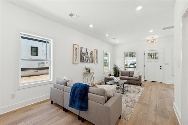 living area with light wood-style floors, baseboards, visible vents, and recessed lighting