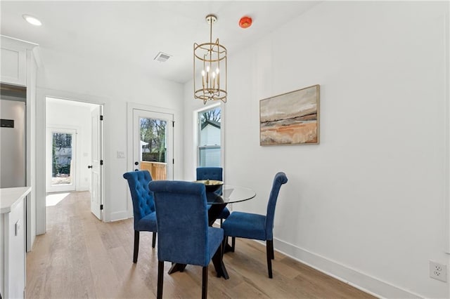 dining space with a notable chandelier, light wood finished floors, recessed lighting, visible vents, and baseboards