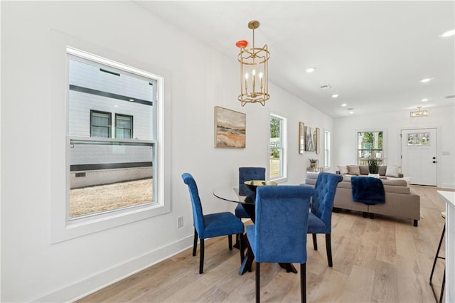 dining space with baseboards, recessed lighting, a chandelier, and light wood-style floors