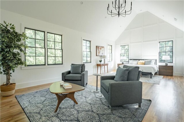 bedroom with hardwood / wood-style flooring, an inviting chandelier, and high vaulted ceiling