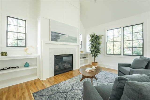 living room featuring a healthy amount of sunlight, hardwood / wood-style floors, and high vaulted ceiling