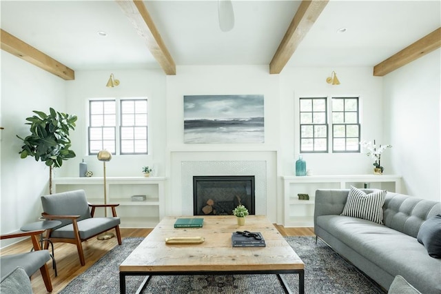 living room featuring beamed ceiling, hardwood / wood-style floors, and a healthy amount of sunlight