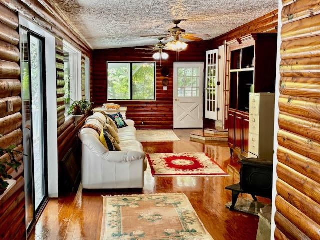 437 Apple Rdg Unit 2, Dawsonville, GA 30534 - living room featuring ceiling fan, wood finished floors, vaulted ceiling, a textured ceiling, and a wood stove