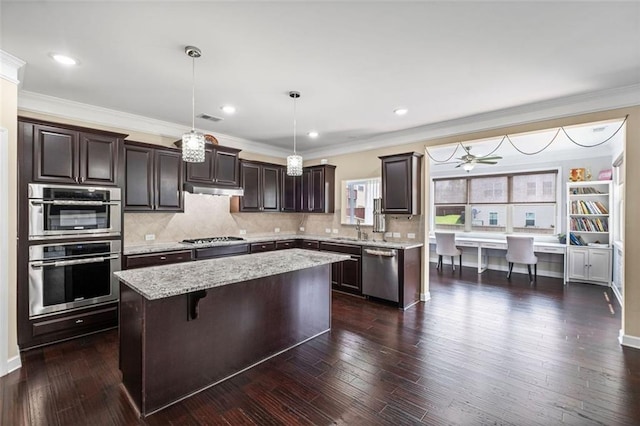 745 Newfield Ln, Alpharetta, GA 30004 - kitchen with appliances with stainless steel finishes, dark brown cabinets, a center island, under cabinet range hood, and tasteful backsplash