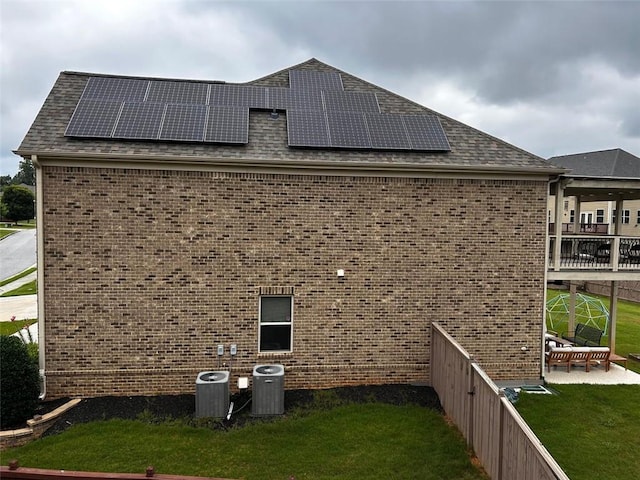 745 Newfield Ln, Alpharetta, GA 30004 - view of side of home with brick siding, solar panels, a lawn, and a shingled roof