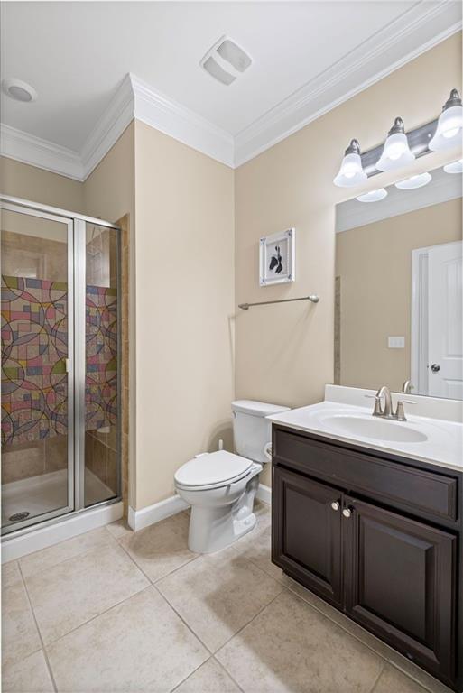 745 Newfield Ln, Alpharetta, GA 30004 - bathroom featuring ornamental molding, vanity, tile patterned floors, and a stall shower