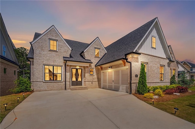 2565 Cork St, Braselton, GA 30517 - view of front of home featuring brick siding, french doors, driveway, a garage, and board and batten siding