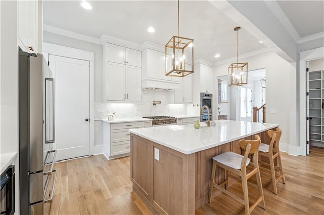 2565 Cork St, Braselton, GA 30517 - kitchen featuring appliances with stainless steel finishes, light wood finished floors, light countertops, ornamental molding, and recessed lighting