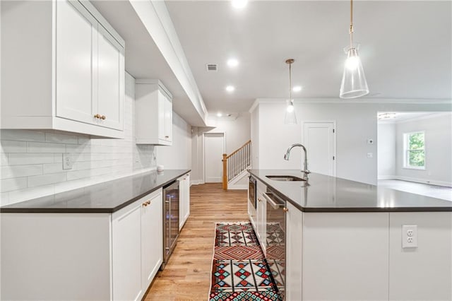 2565 Cork St, Braselton, GA 30517 - kitchen featuring a sink, dark countertops, beverage cooler, light wood-style floors, and backsplash