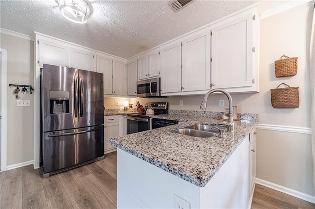 kitchen featuring white cabinetry, stainless steel appliances, sink, and light stone counters