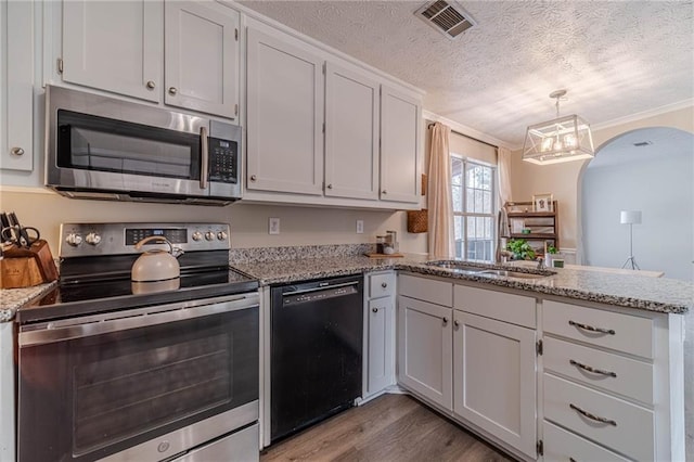 kitchen with pendant lighting, sink, white cabinetry, stainless steel appliances, and kitchen peninsula