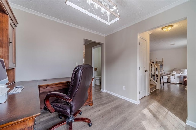 home office with crown molding, a textured ceiling, and light wood-type flooring